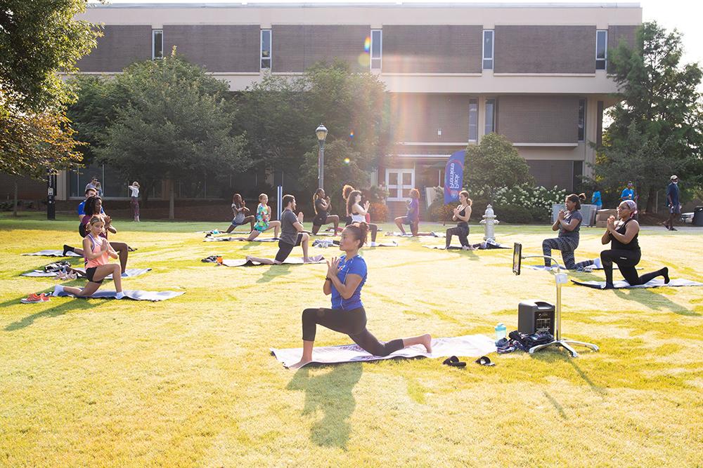 students doing yoga outside of library